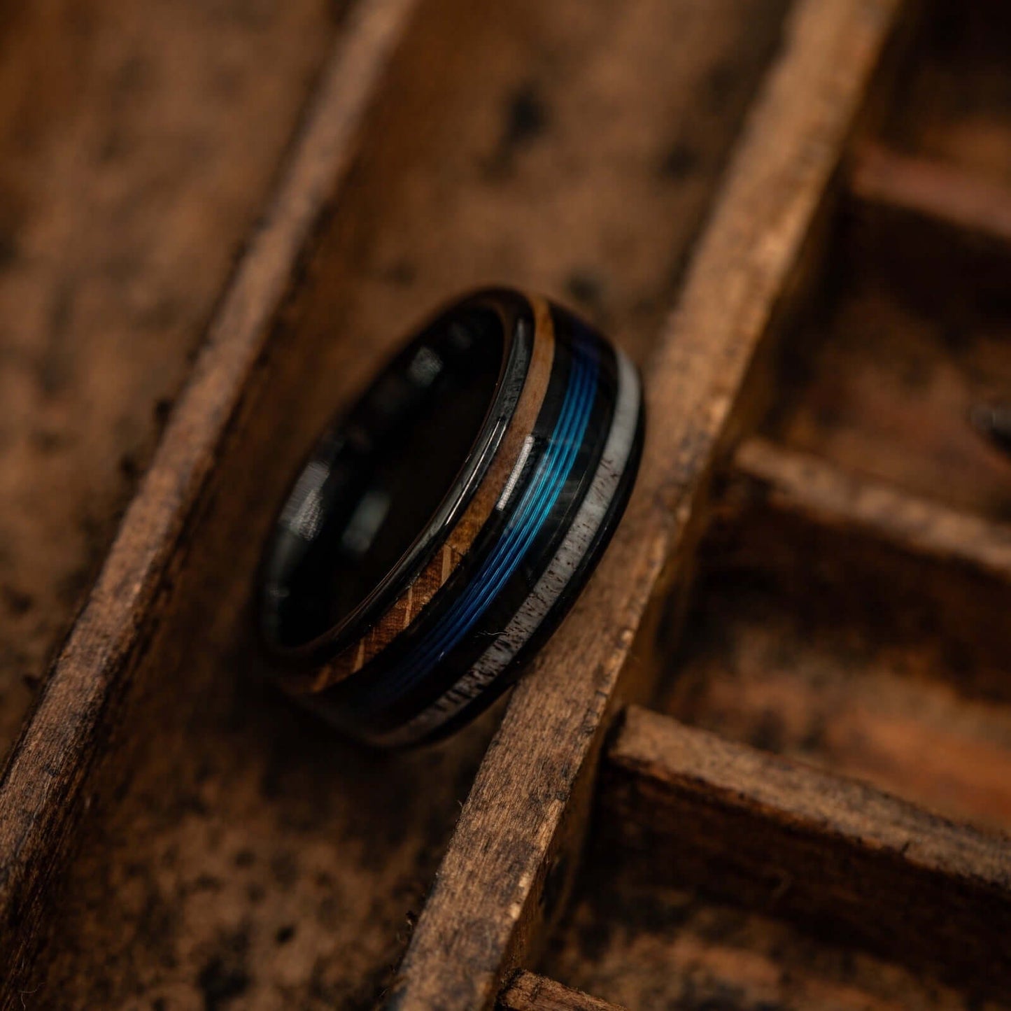 Fishing-themed wedding ring with antler and whiskey barrel wood inlays, perfect for outdoor enthusiasts.