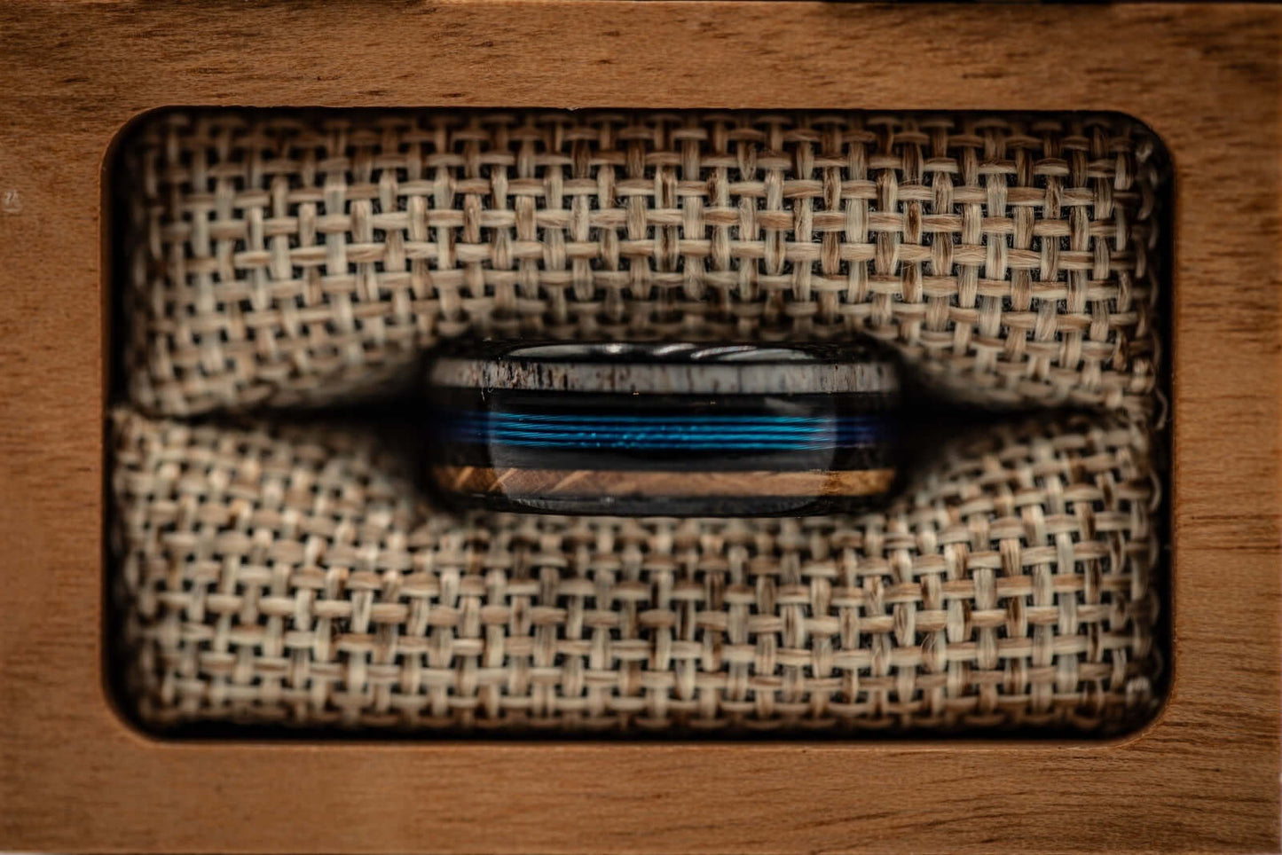 Rustic wedding band for fishermen, crafted with antler, wood, and blue fishing line detailing.