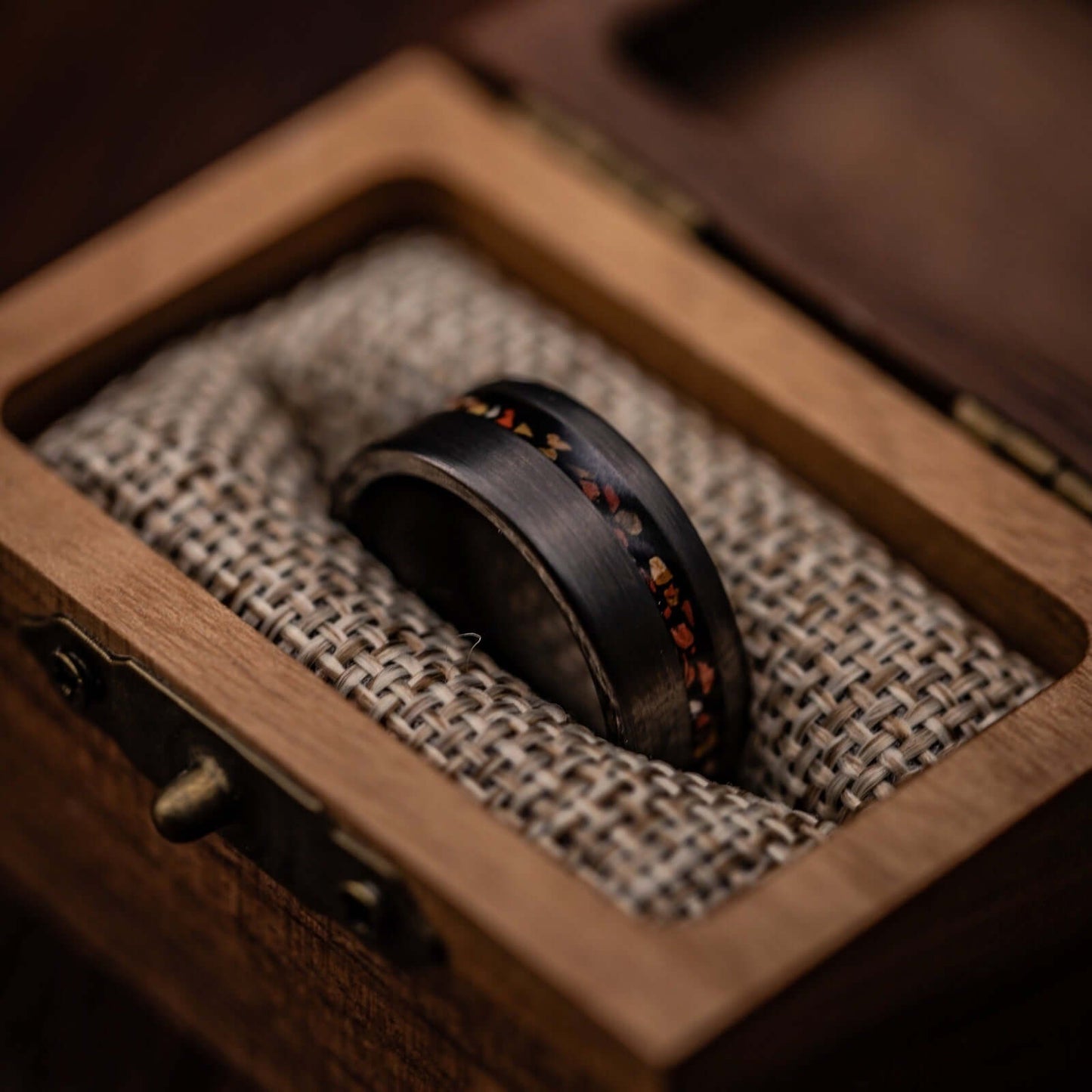 Distinctive wedding band showcasing silver brushed tungsten and vibrant red dinosaur bone.