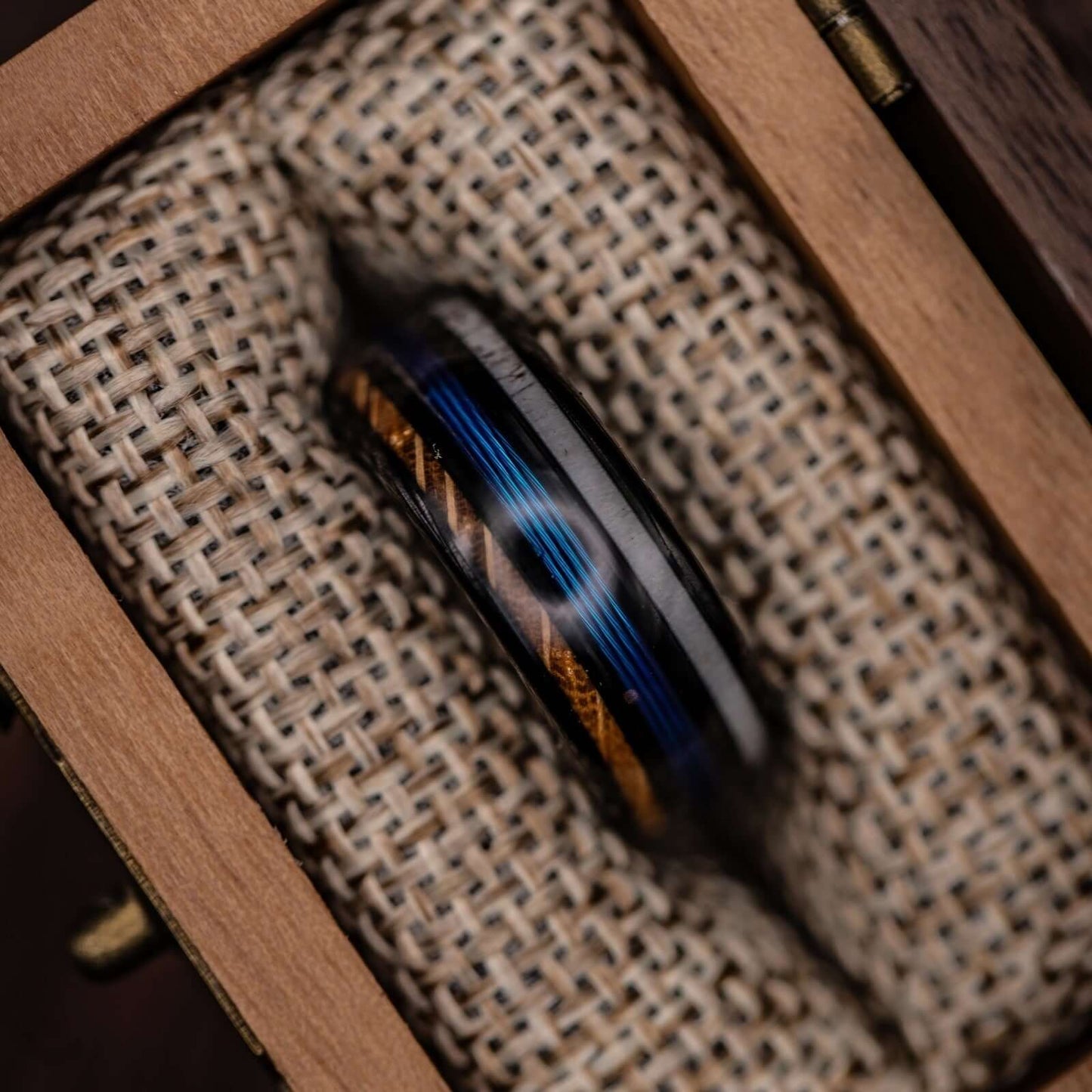Whiskey barrel wood and antler ring with a blue fishing line motif, ideal for nature lovers.
