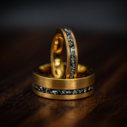 Matching his and hers yellow gold meteorite wedding rings, symbolizing everlasting love.