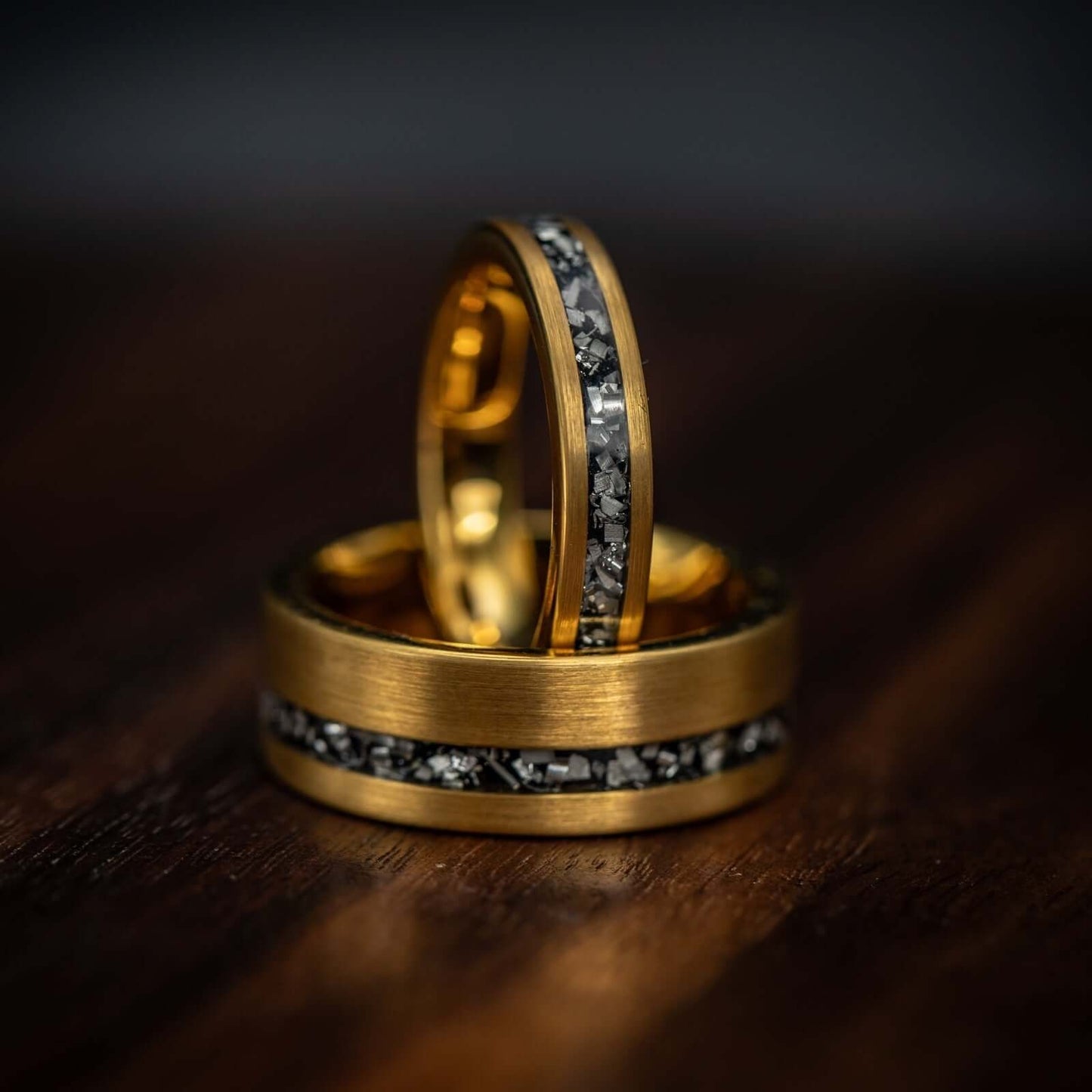 Couples 8mm and 4mm yellow gold meteorite rings the 8mm laying and 4mm standing on top of it
