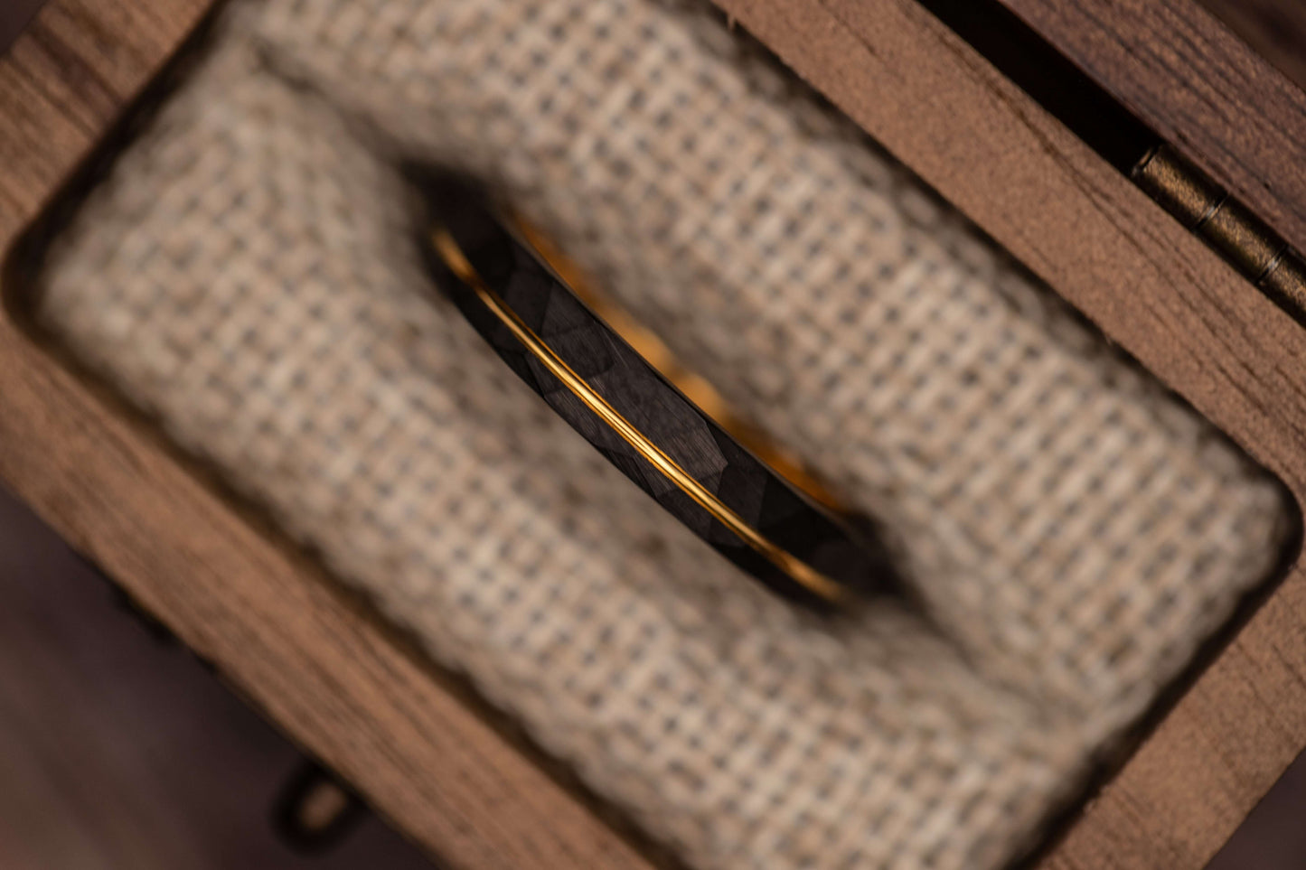 Unique hammered ring featuring black finish and yellow gold detailing, perfect as an engagement or wedding band