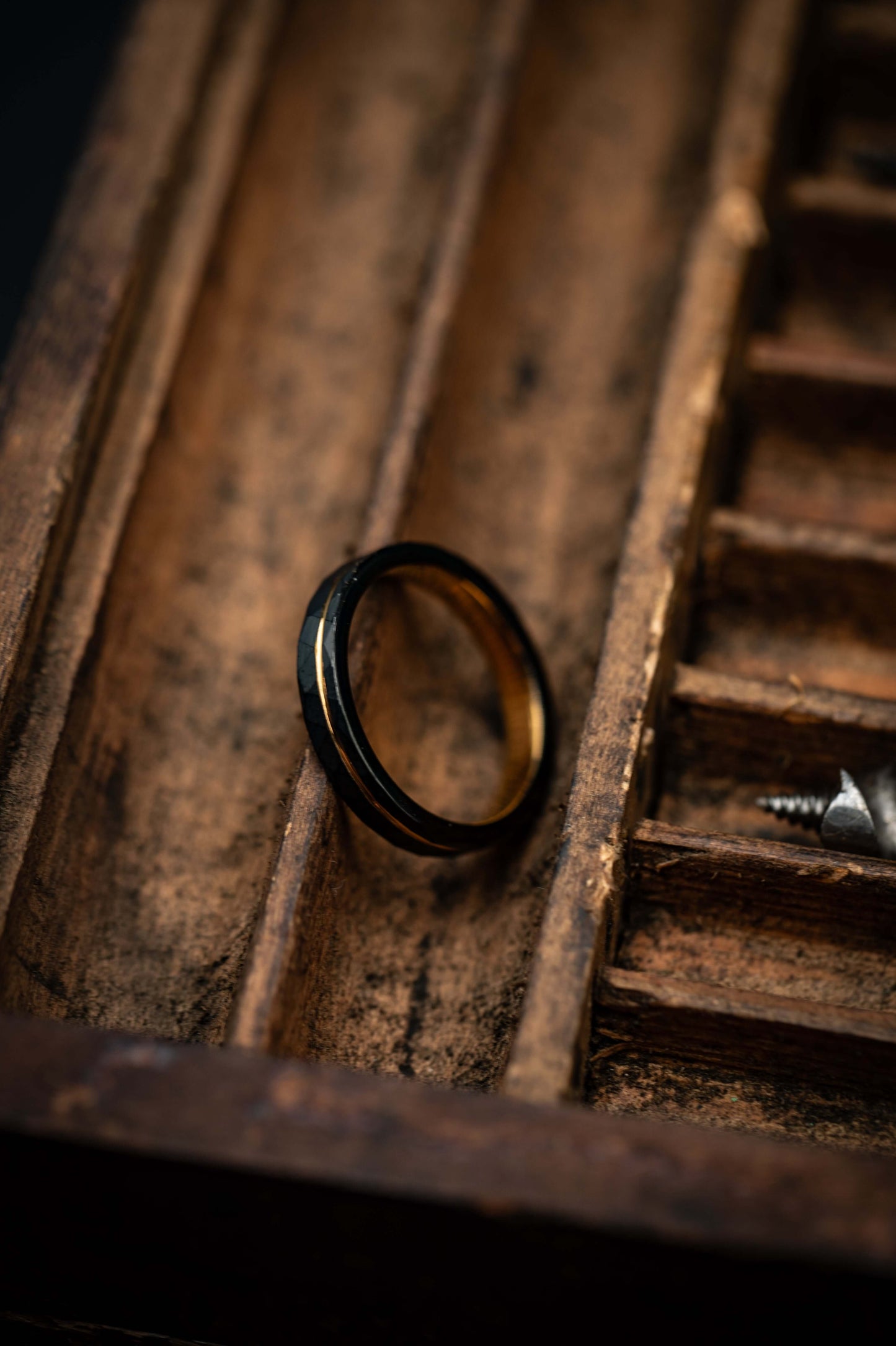 Yellow gold engagement ring featuring a hammered black band, offering a modern and unique design