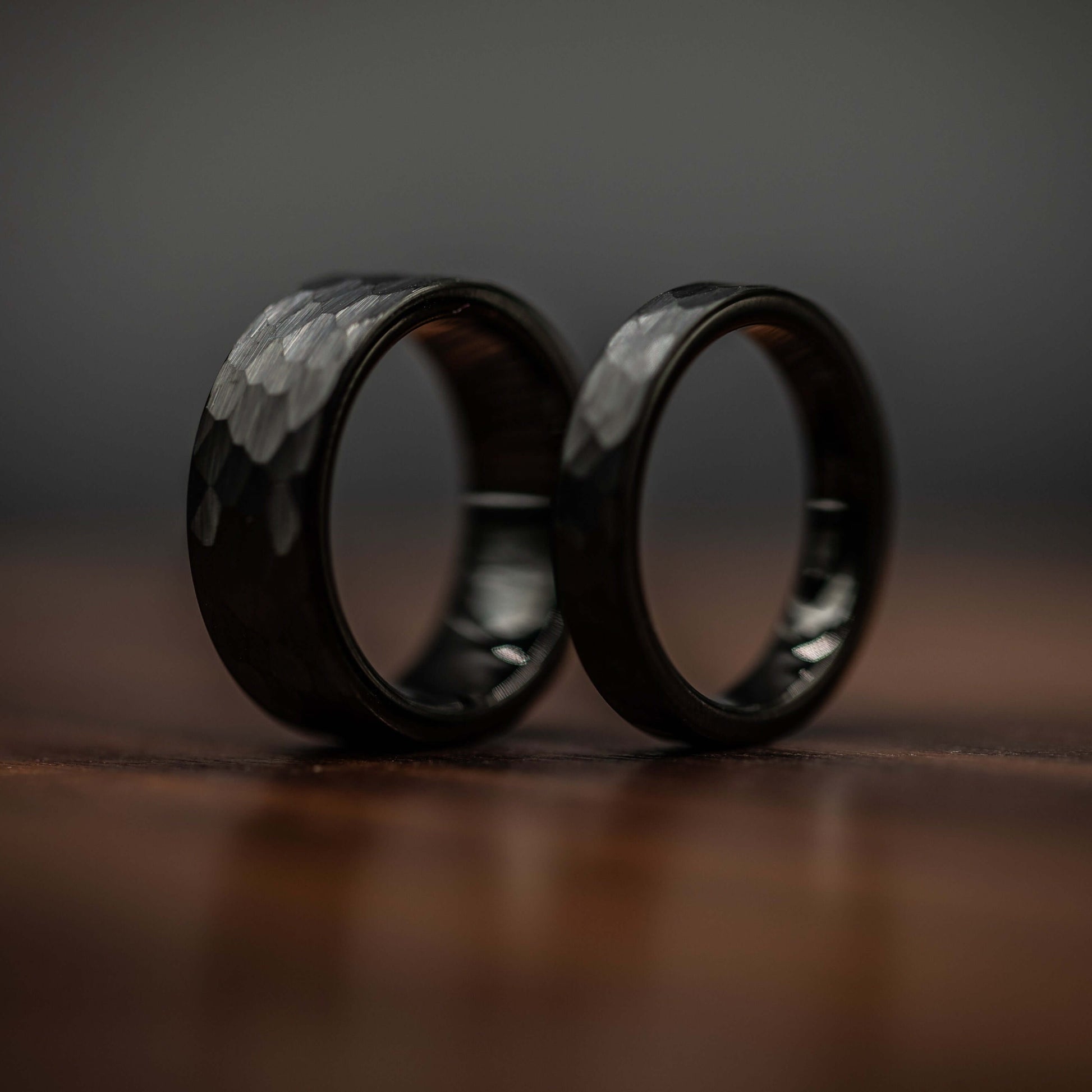 Black hammered tungsten wedding rings set for couples, showcasing unique texture and strong design.