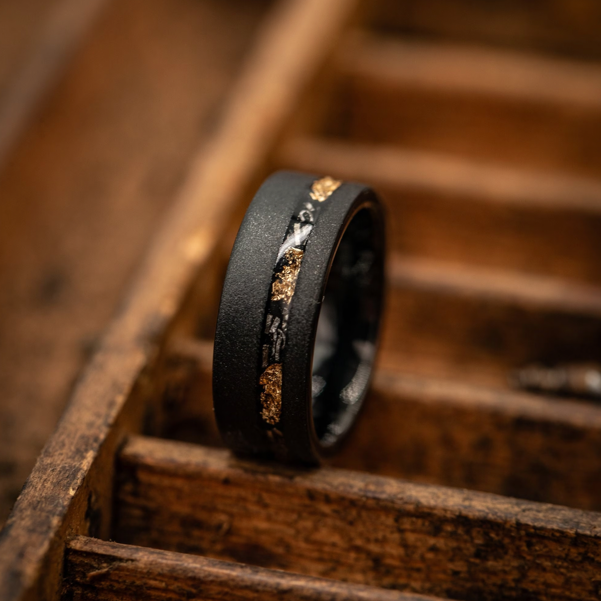 Striking black and gold meteorite ring with sandblasted finish, ideal for weddings or engagements.