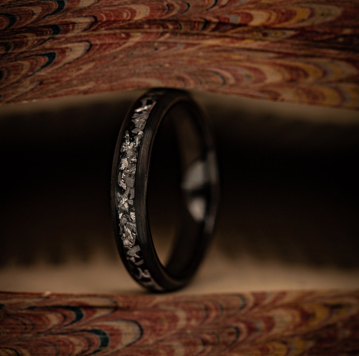 Sleek black meteorite wedding band for women, offering a modern and unique style.