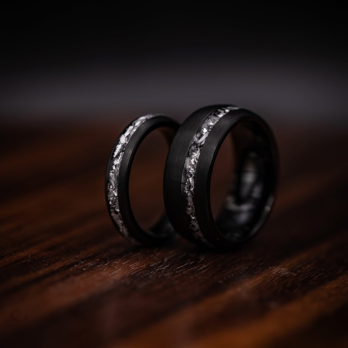 His and hers wedding bands featuring black brushed meteorite