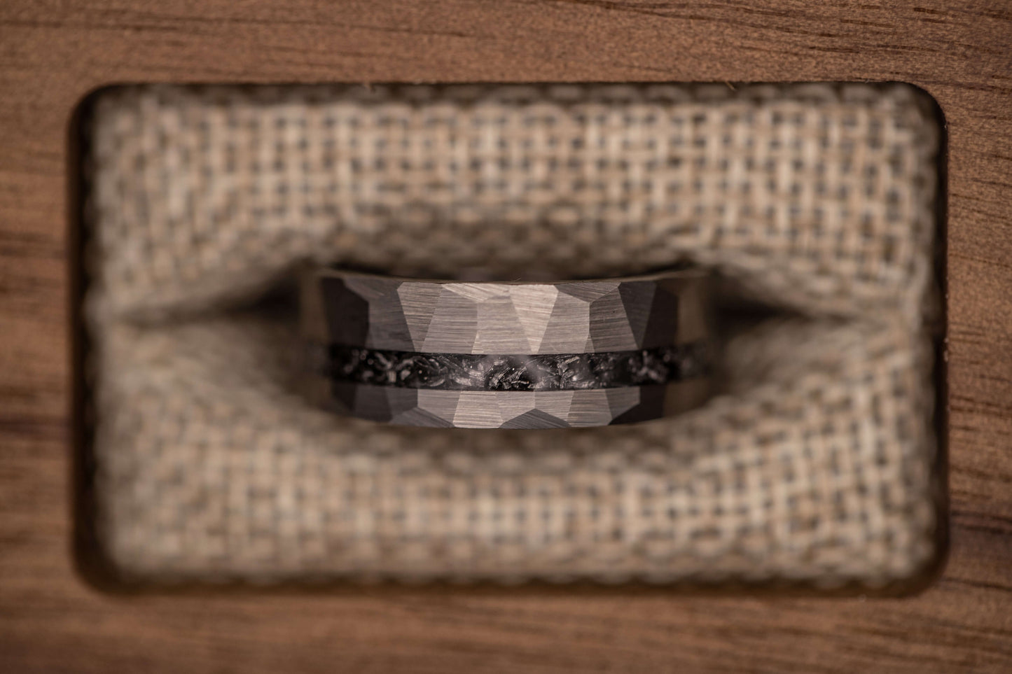 Silver meteorite hammered wedding band featuring a rustic design and inlaid Gibeon meteorite set on a textured background.