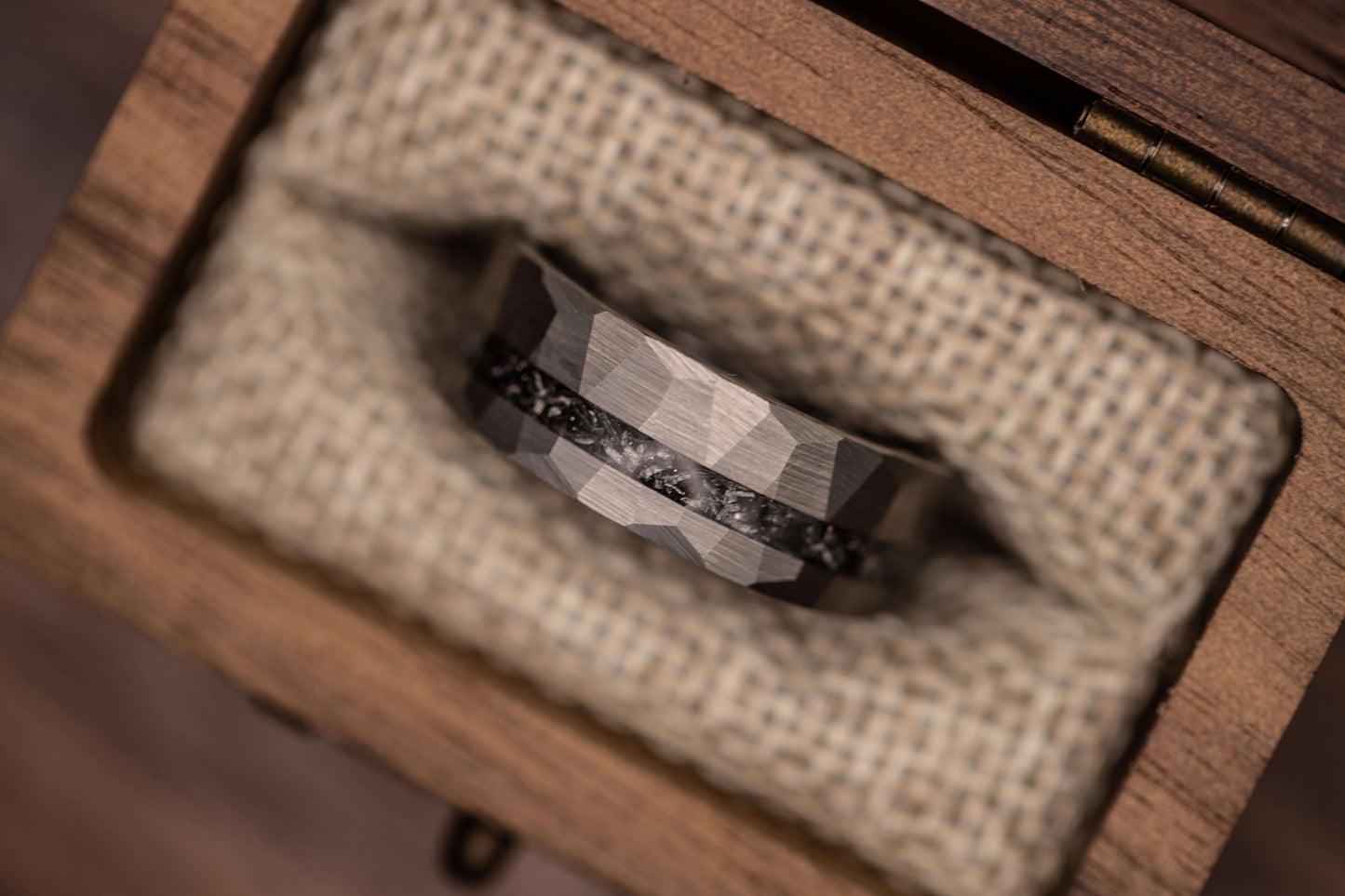 Silver meteorite hammered wedding band with Gibeon meteorite inlay displayed in a wooden ring box.