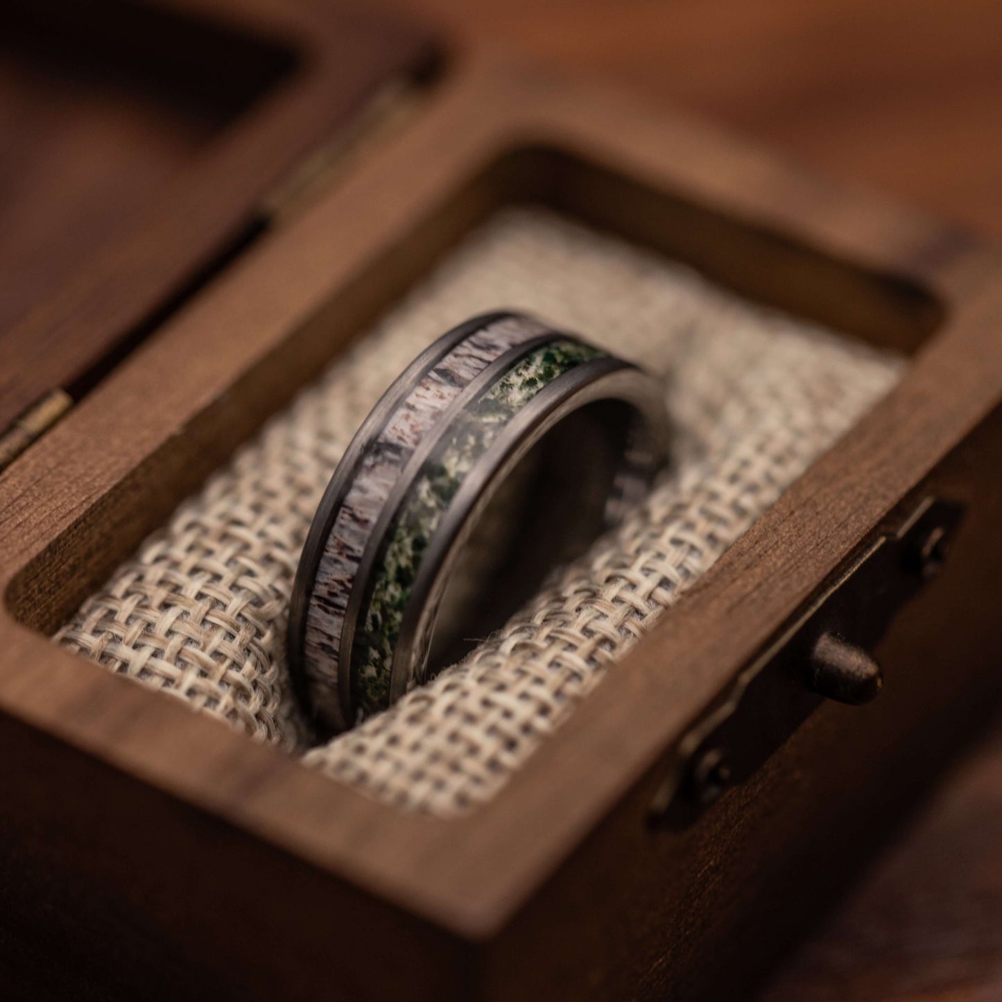 Mens deer antler and moss agate ring in polished silver tungsten, displayed in a decorative wooden box.