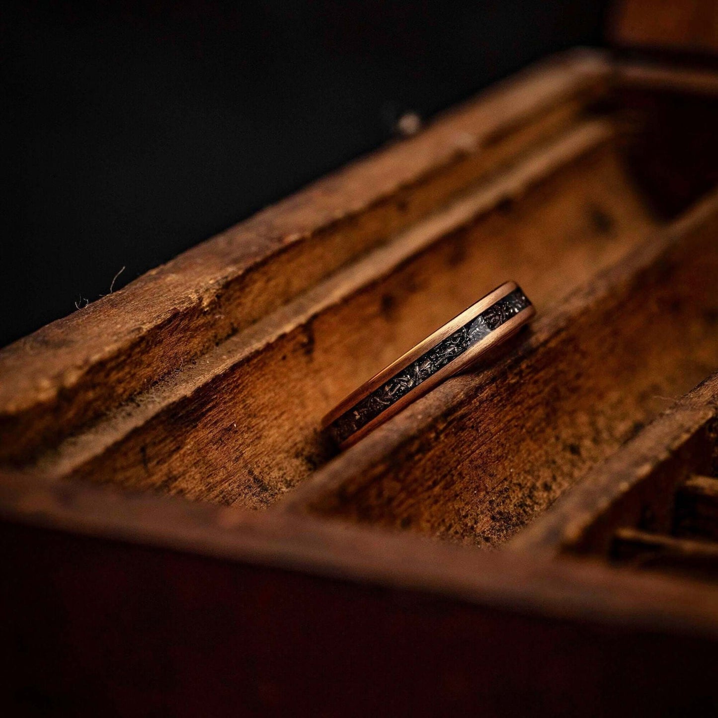 Elegant rose gold wedding ring featuring real meteorite inlay, perfect for engagements.