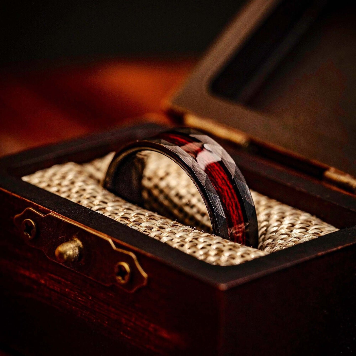 Black 8mm Hammered Wedding ring Set with Red Koa Wood Inlay inside walnut ring box between burlap cushions
