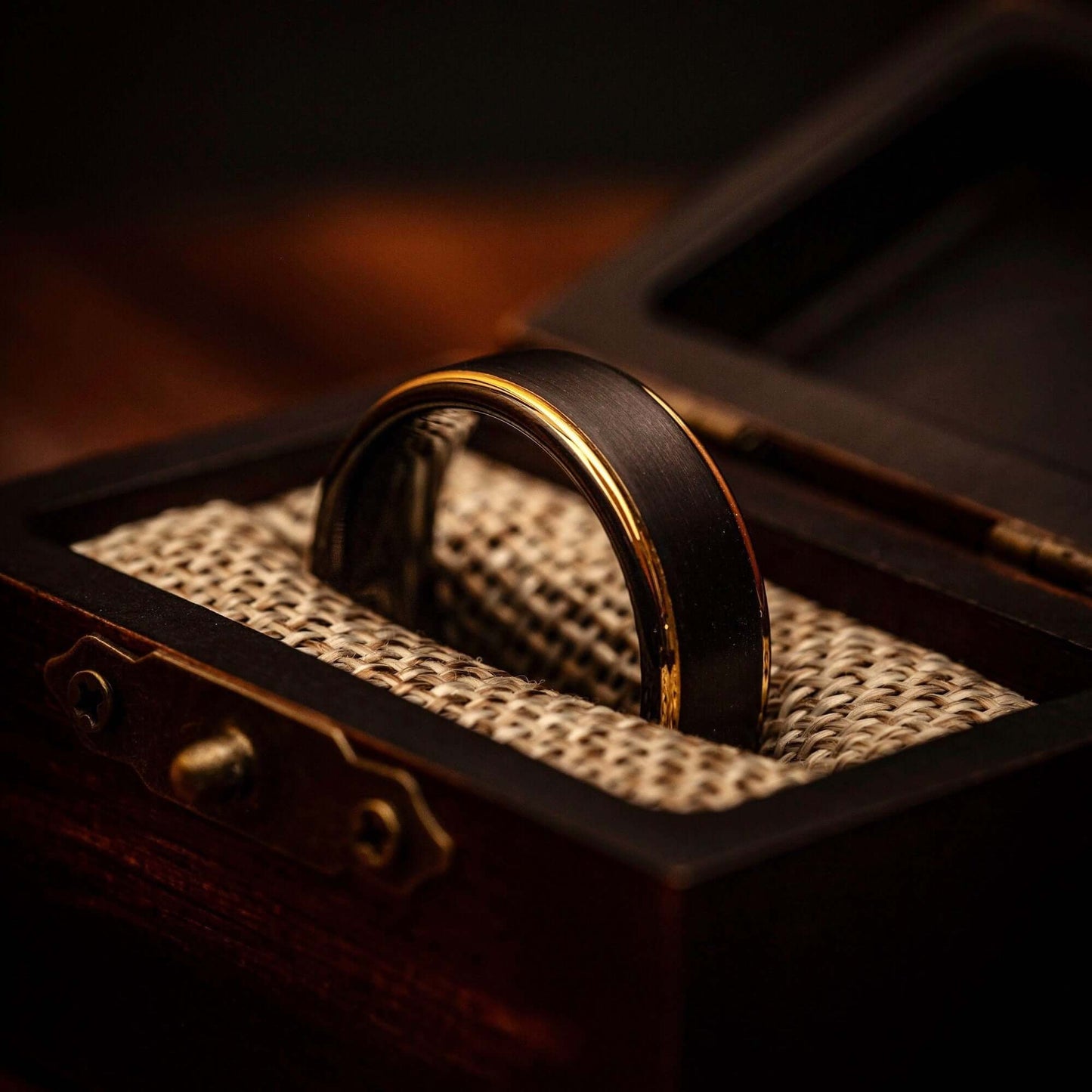 Black tungsten wedding ring with 18k Yellow Gold Step edges in walnut ring box with burlap cushion