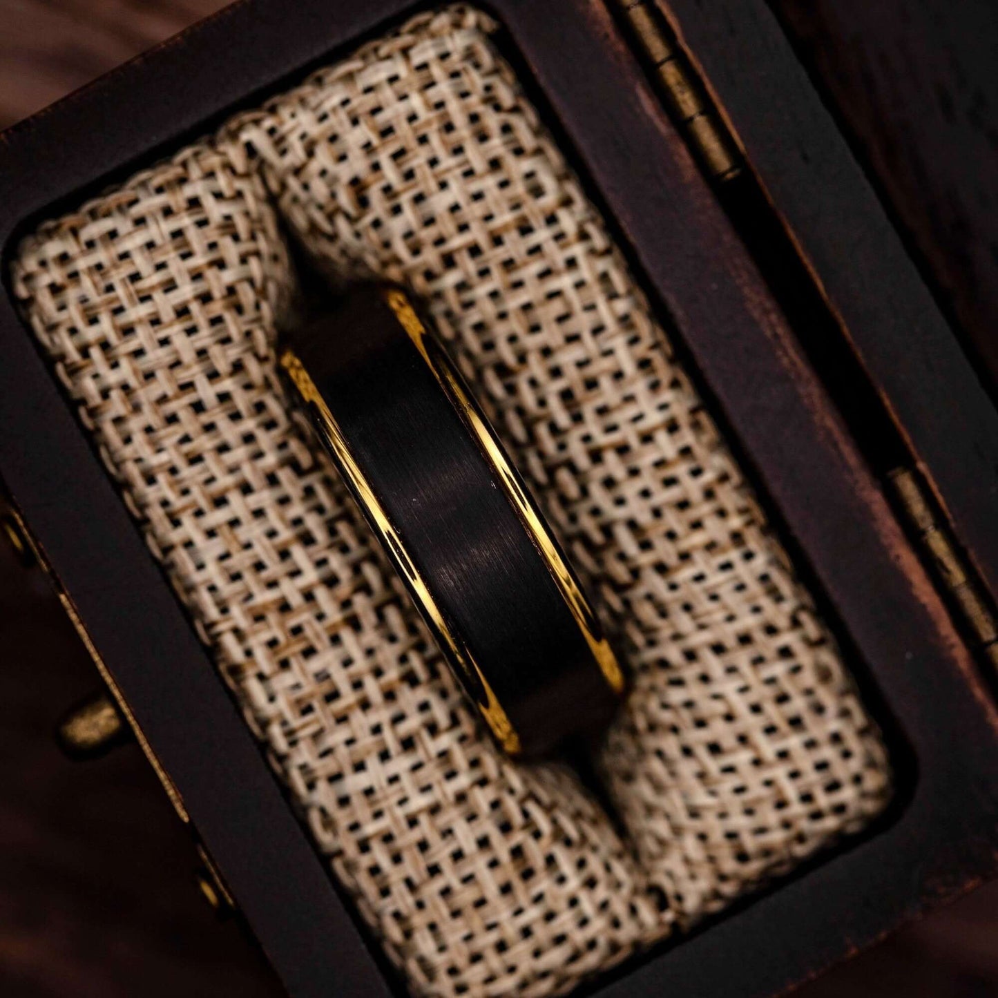 Black tungsten wedding ring with 18k Yellow Gold Step edges in walnut ring box with burlap cushion