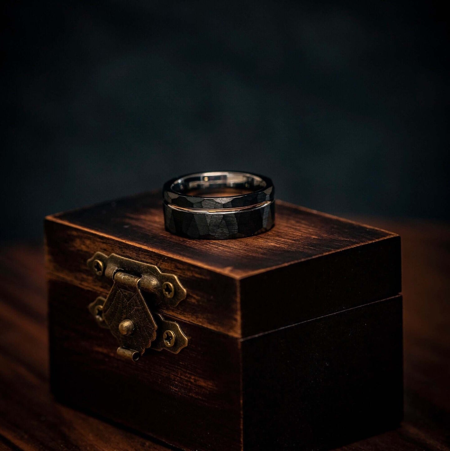 Hammered black wedding band with distinctive yellow gold elements, perfect for engagements.