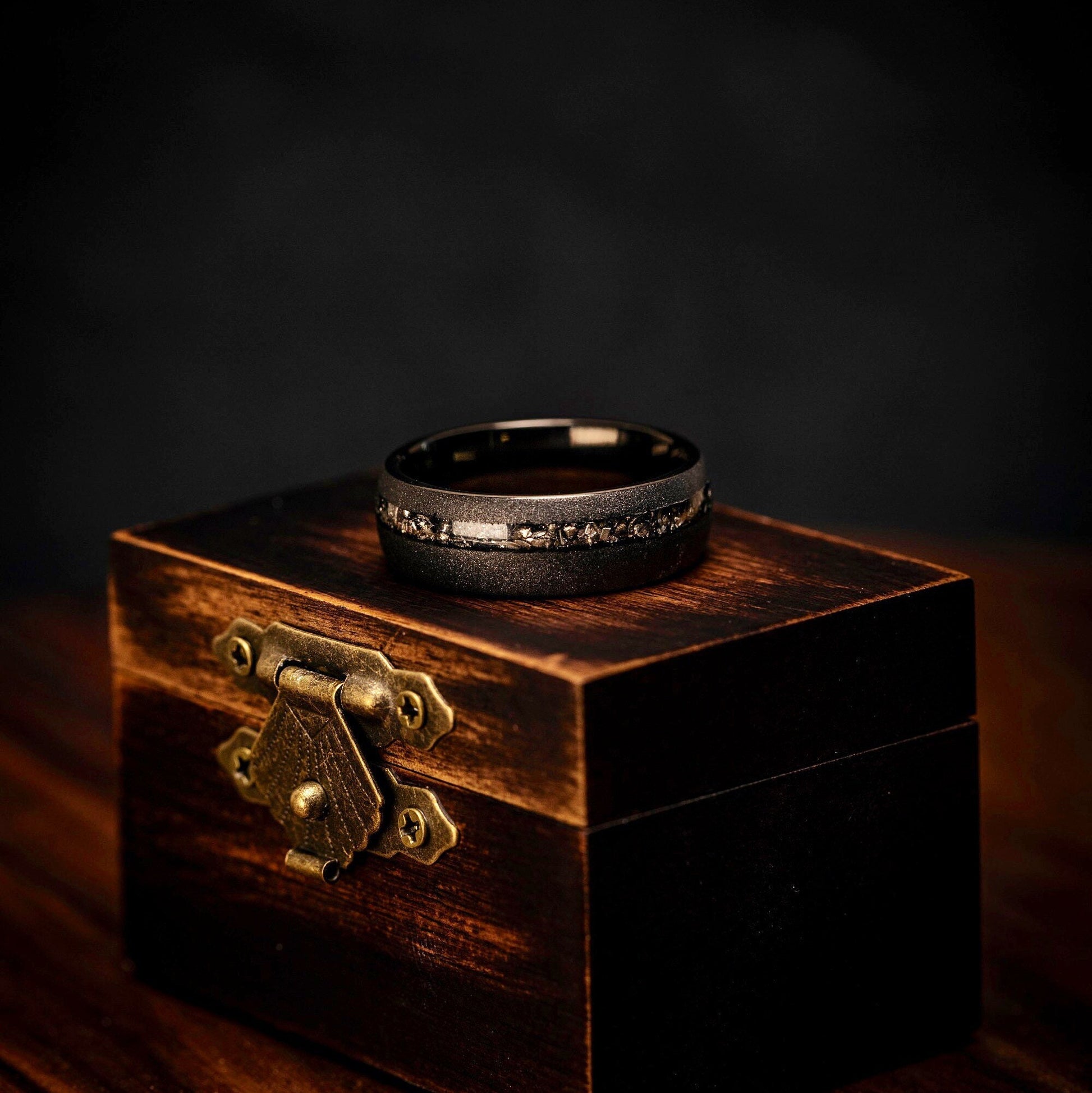 His and hers wedding bands featuring real meteorite and black sandblasted design.