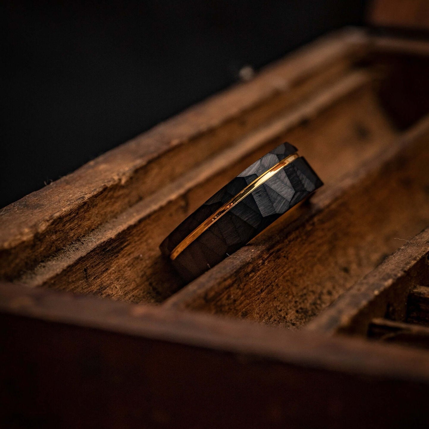 Unique men's wedding ring featuring hammered black finish and yellow gold accents.