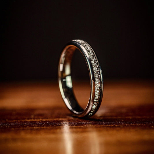 Women's silver wedding band featuring real meteorite, a unique choice for weddings.