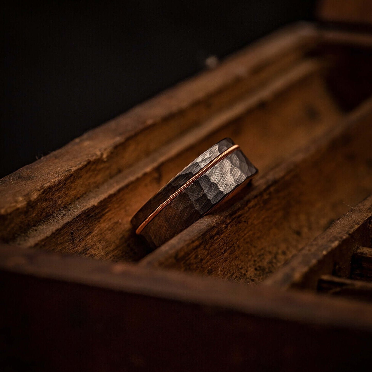 Hammered rose gold and silver wedding band with intricate guitar string design.