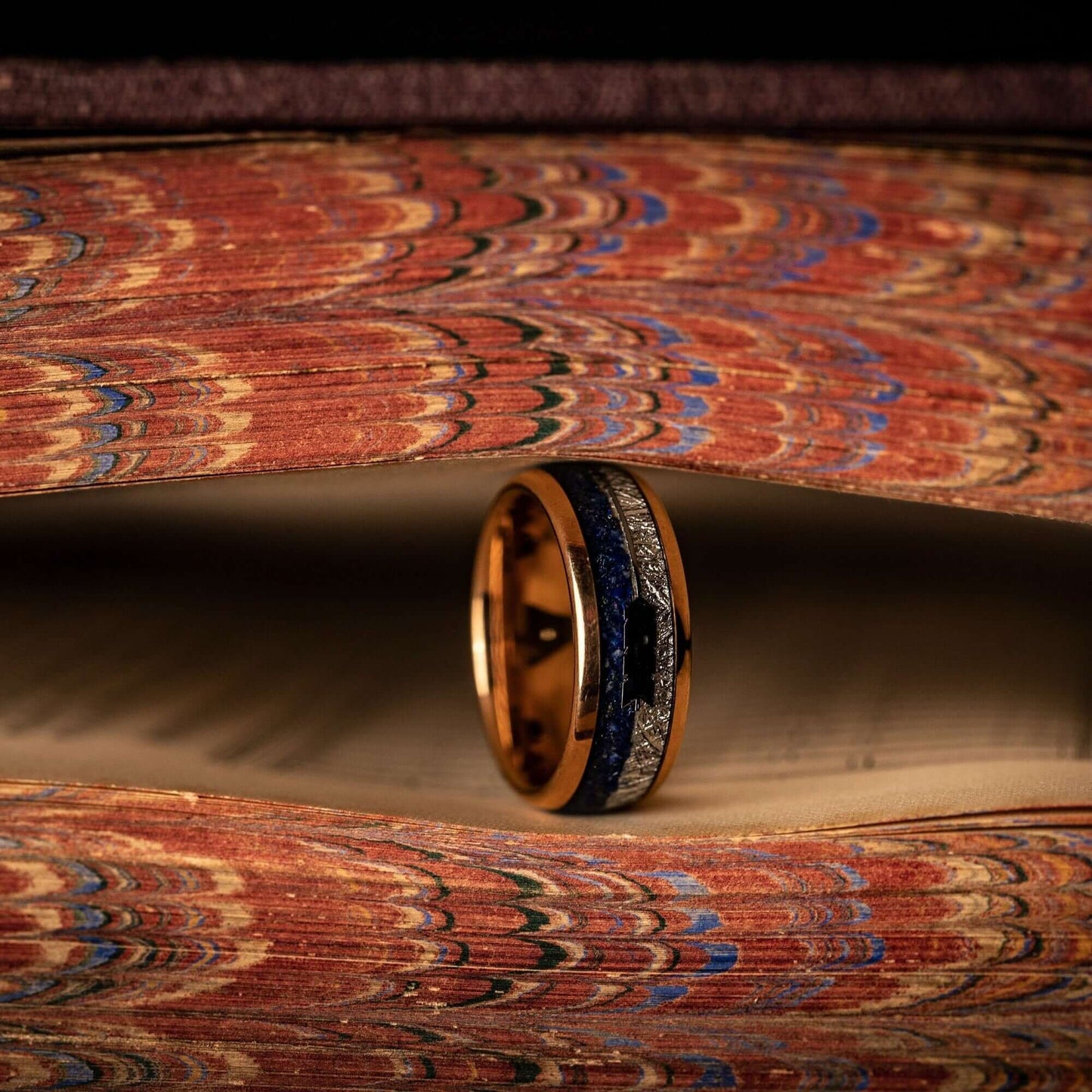 Meteorite wedding band paired with lapis lazuli in a men's rose gold wedding ring design.