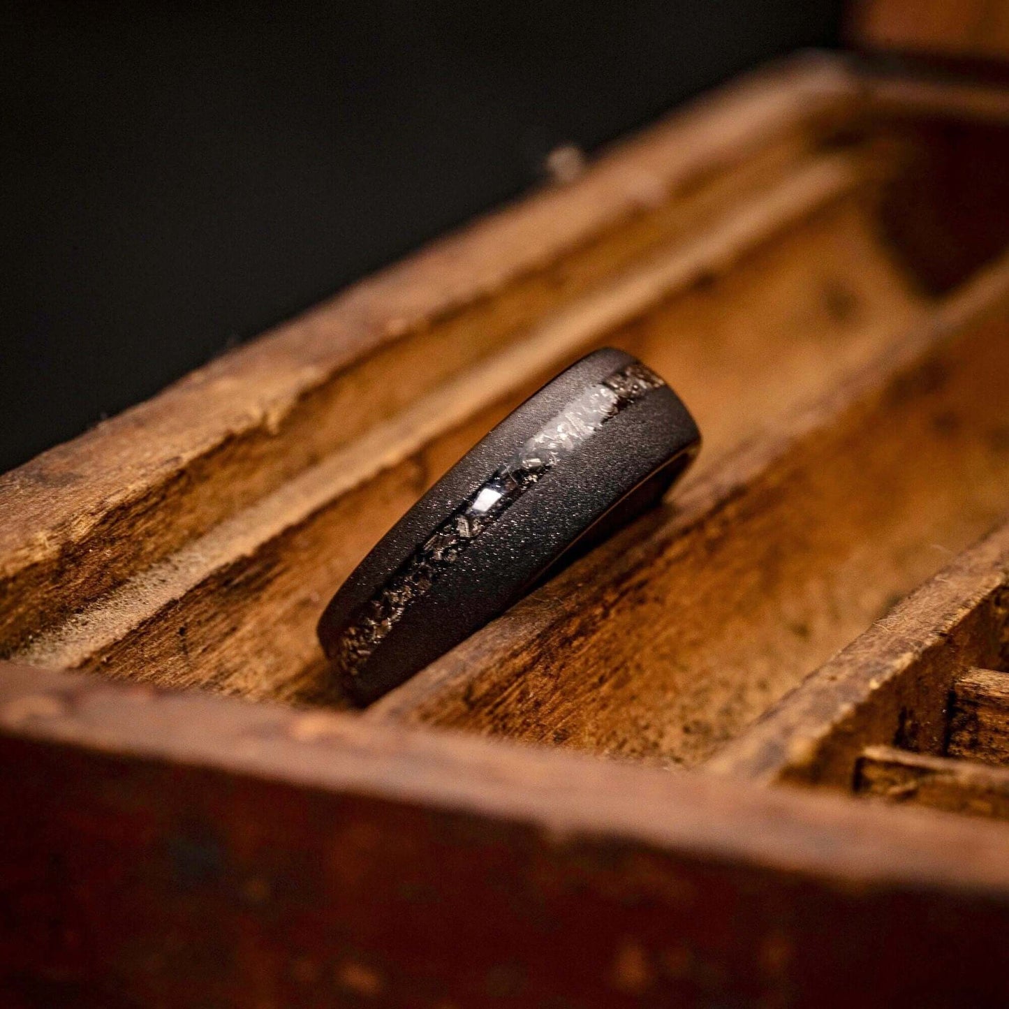 Sleek men's wedding band in black tungsten, accented by authentic meteorite.