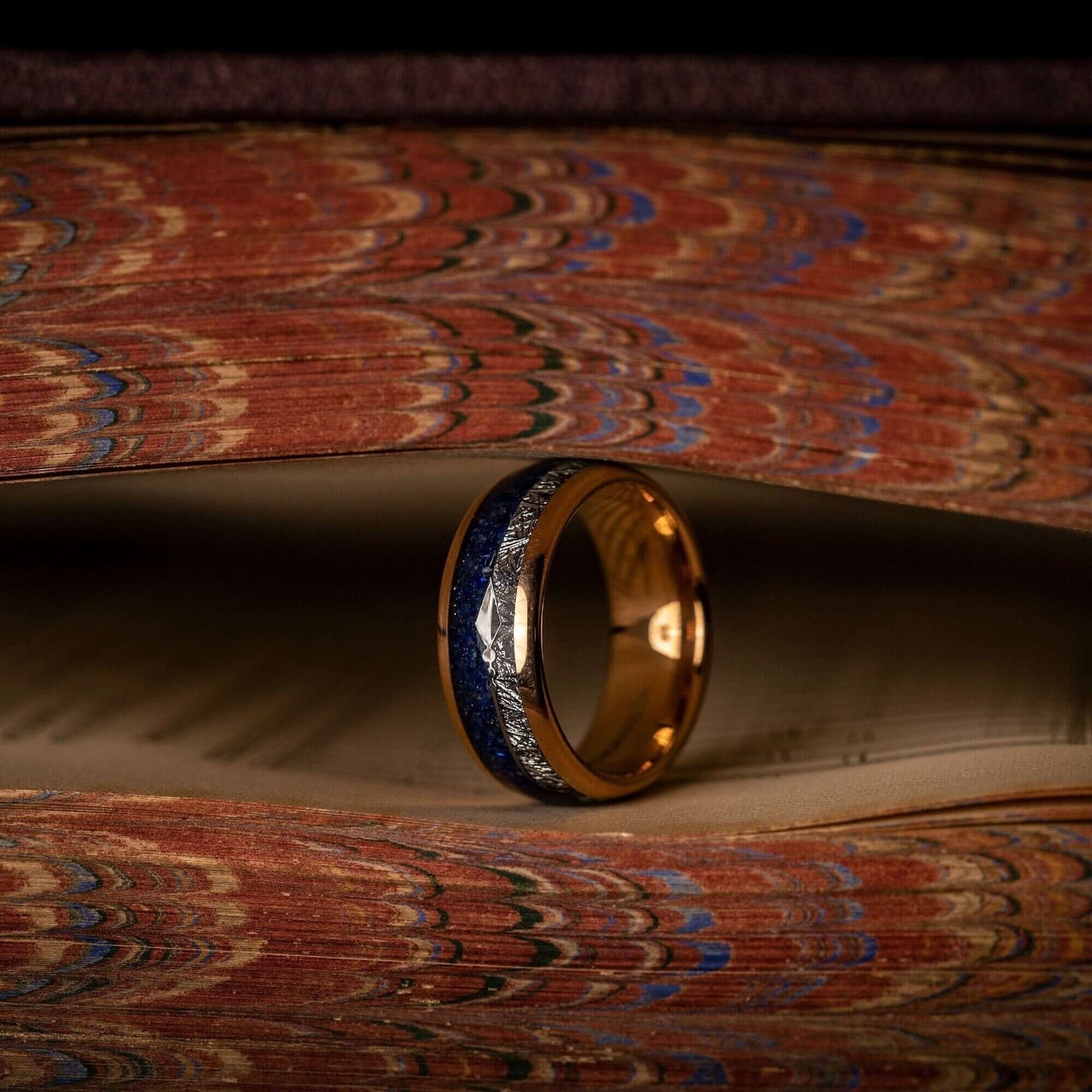 Men's rose gold wedding band with lapis lazuli and meteorite detailing.