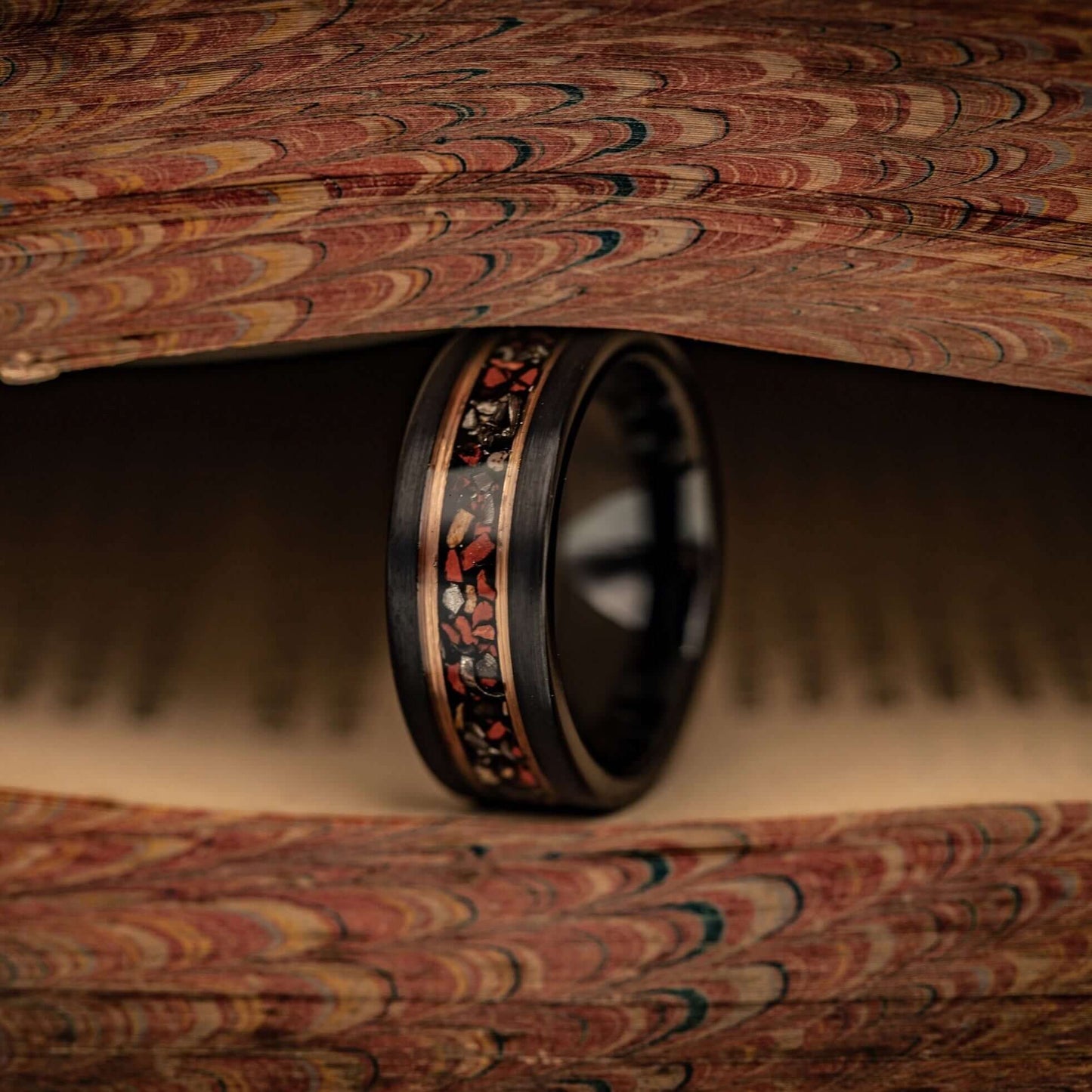 8mm Dinosaur Bone wedding band with tyrannosaurus rex bone and meteorite inlay standing between pages of a book