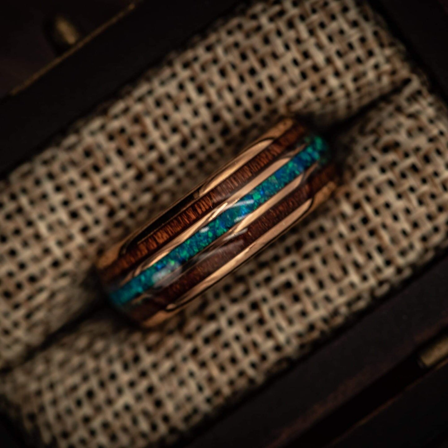 Sophisticated wood wedding ring with rose gold accents and mesmerizing blue opal.