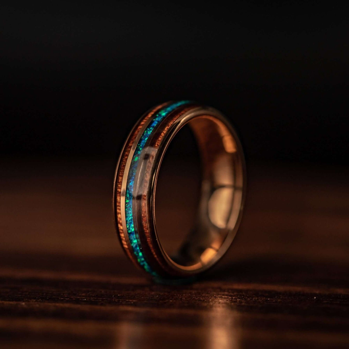 Sophisticated wood wedding ring with rose gold accents and mesmerizing blue opal.