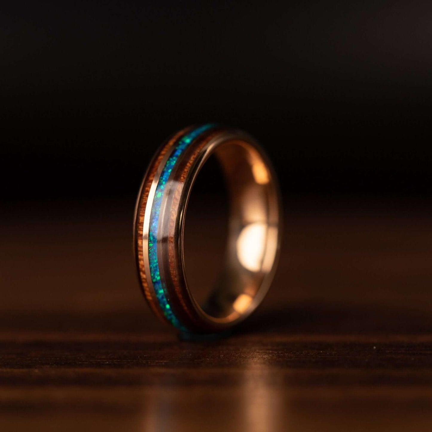 Rose gold ring featuring 6mm width, Koa wood, and stunning blue opal detail.