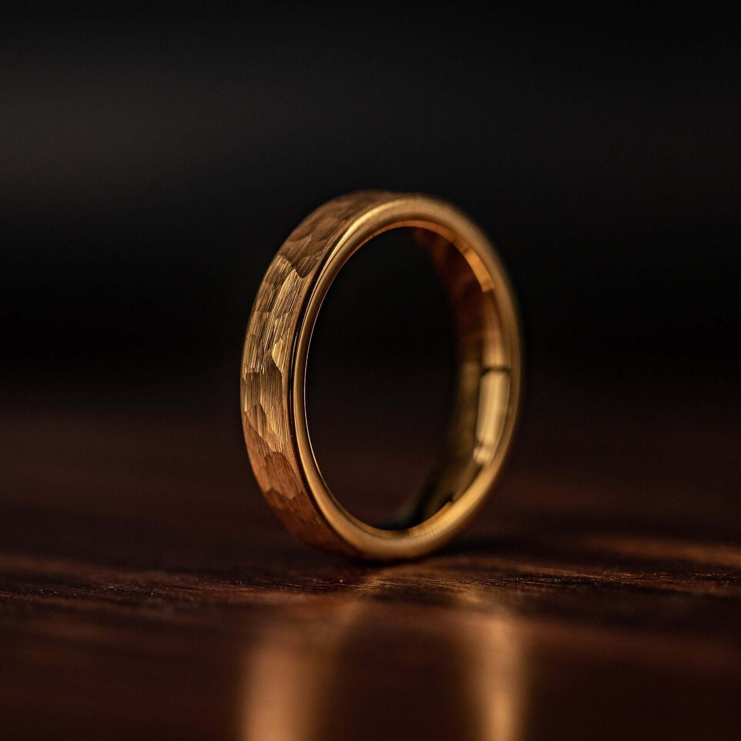 Women's 4mm Hammered Yellow Gold Tungsten Wedding Ring standing on its side