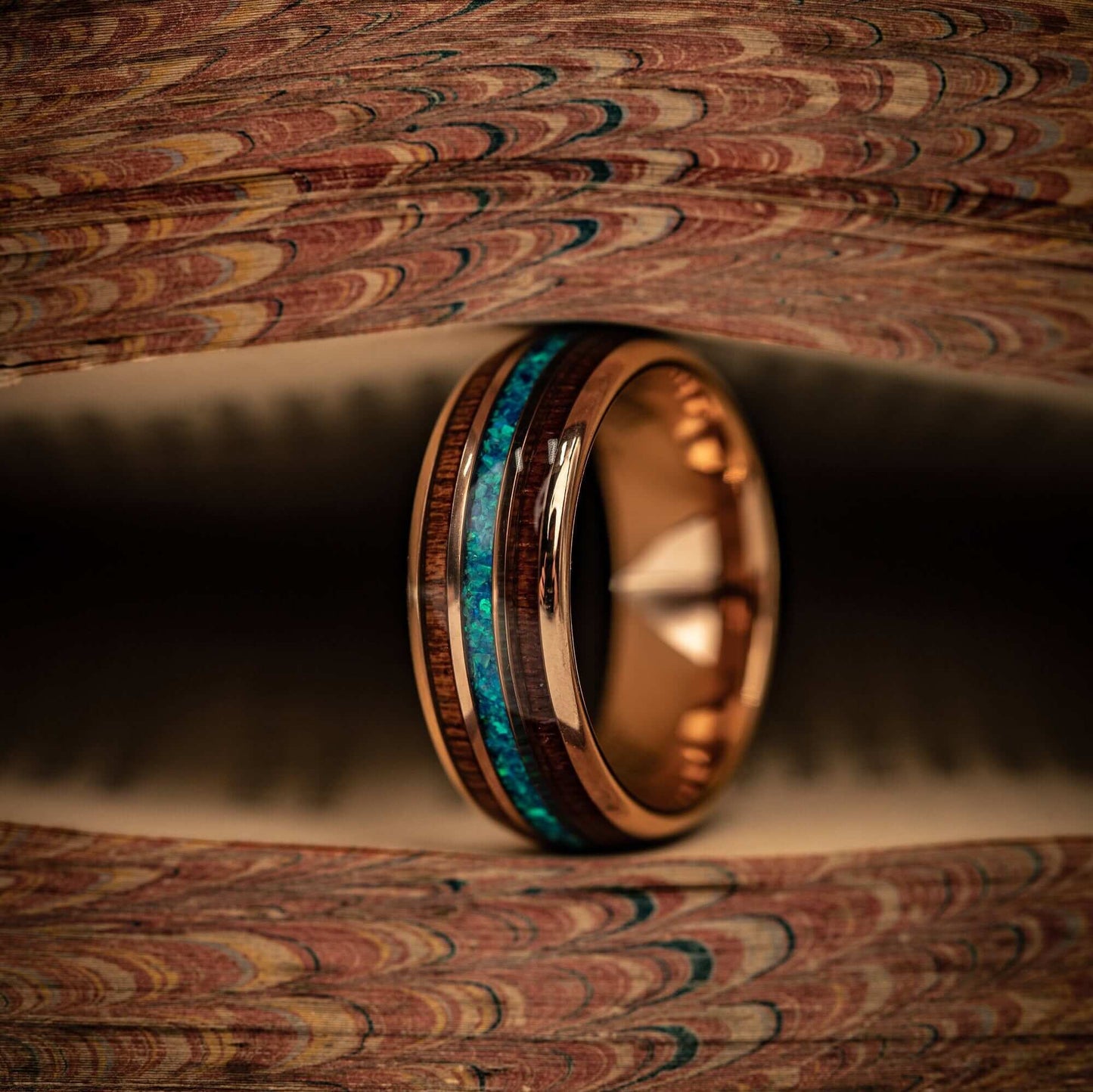 Distinctive 8mm wedding band crafted with rose gold, Koa wood, and blue opal.