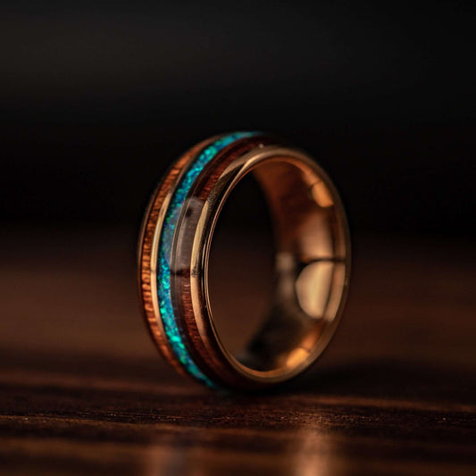 Unique rose gold ring with Koa wood and vibrant blue opal, perfect for weddings.