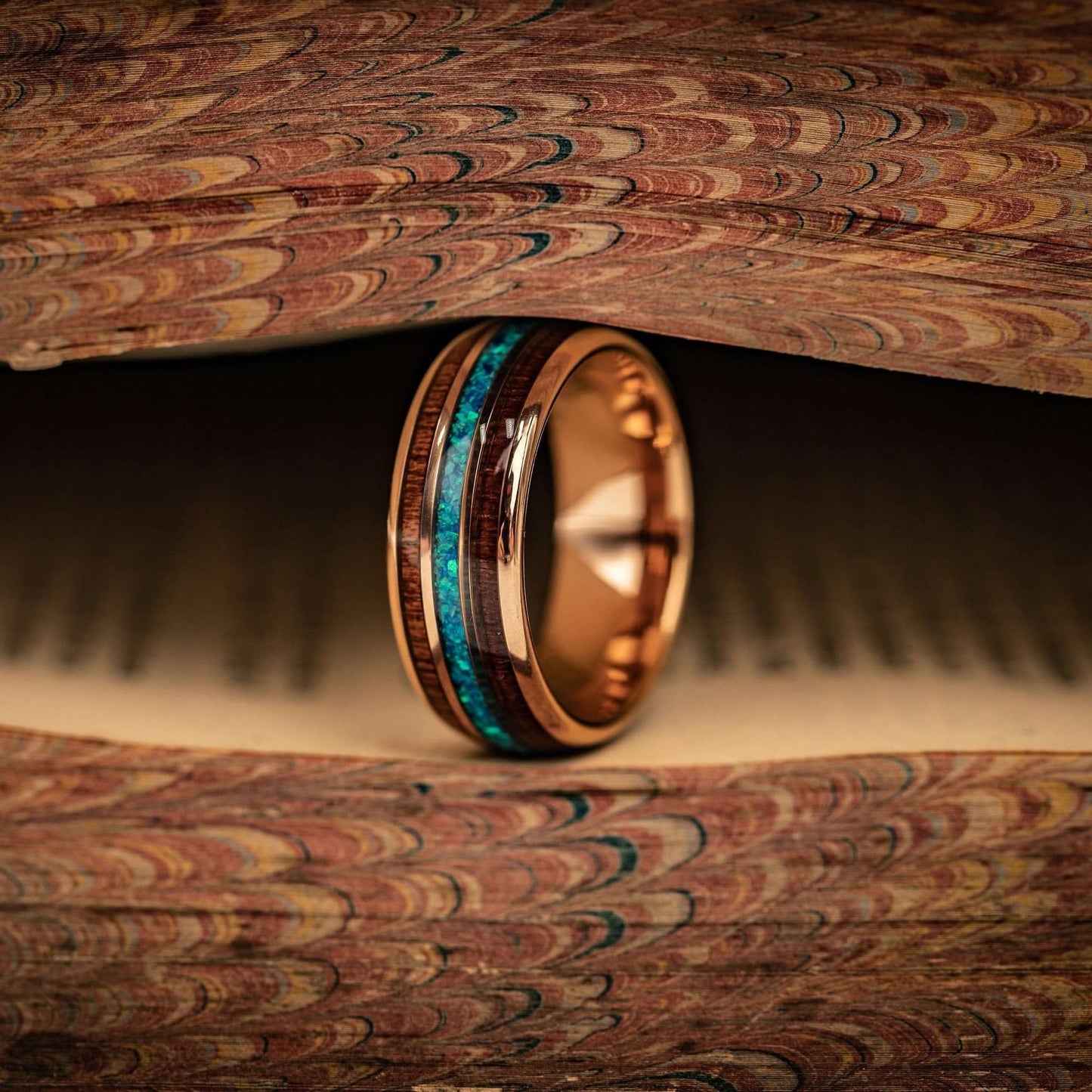 Rose gold wedding band featuring Hawaiian Koa wood and captivating blue opal.