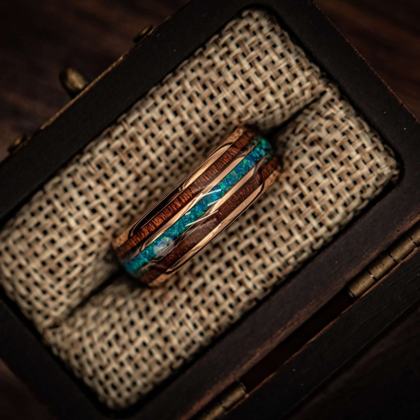 Rose gold wedding ring adorned with Hawaiian Koa wood and stunning blue opal.