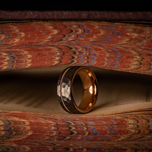 Men's wedding band with hammered rose gold and silver, featuring guitar string detail.