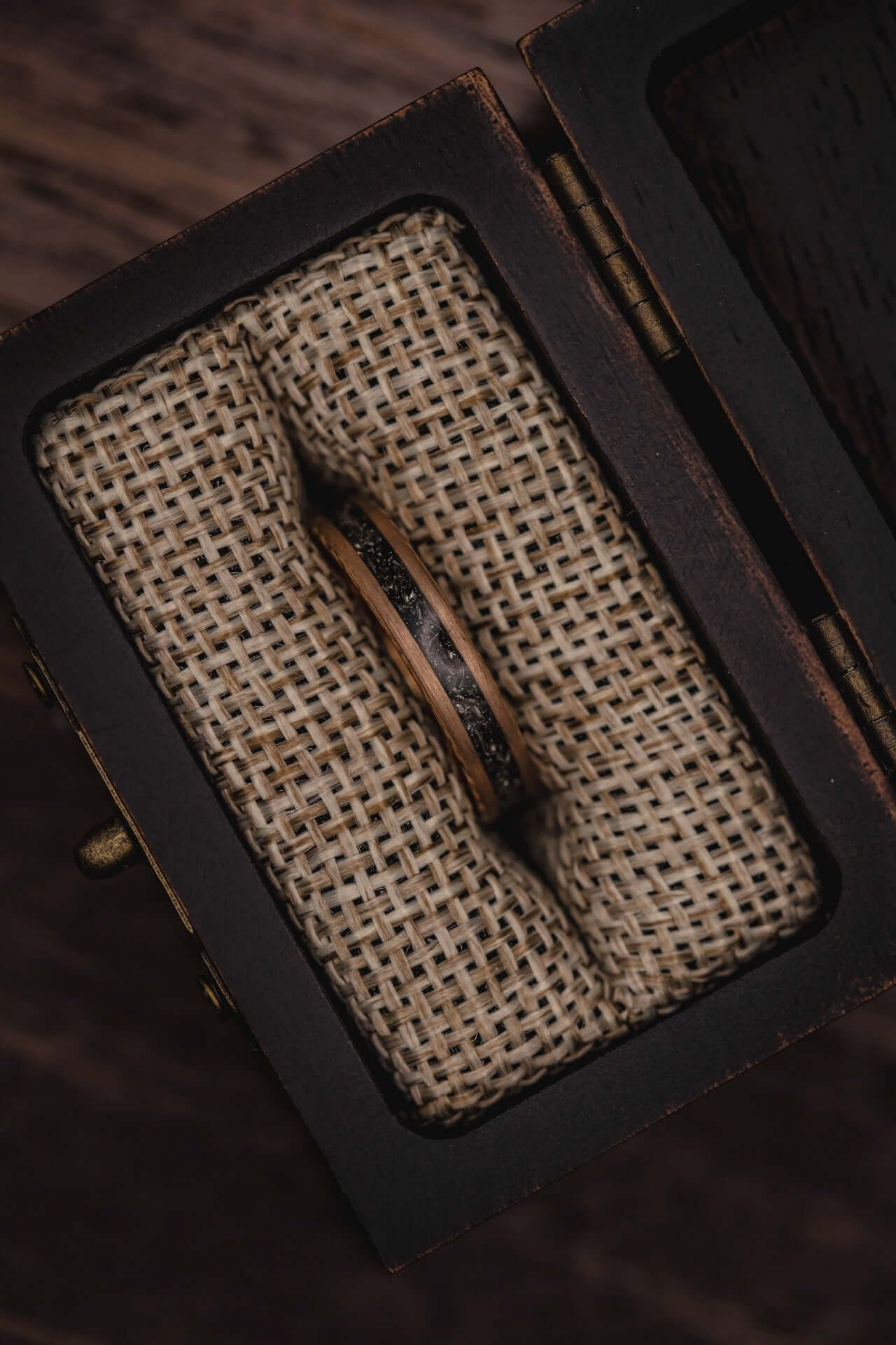 Handcrafted women's ring displayed in a vintage box with natural fabric cushion, showcasing unique craftsmanship.