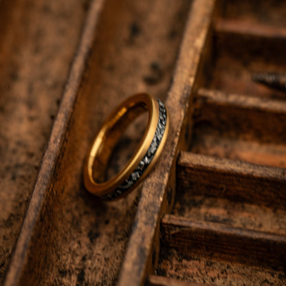 yellow gold meteorite ring leaning on its side in box