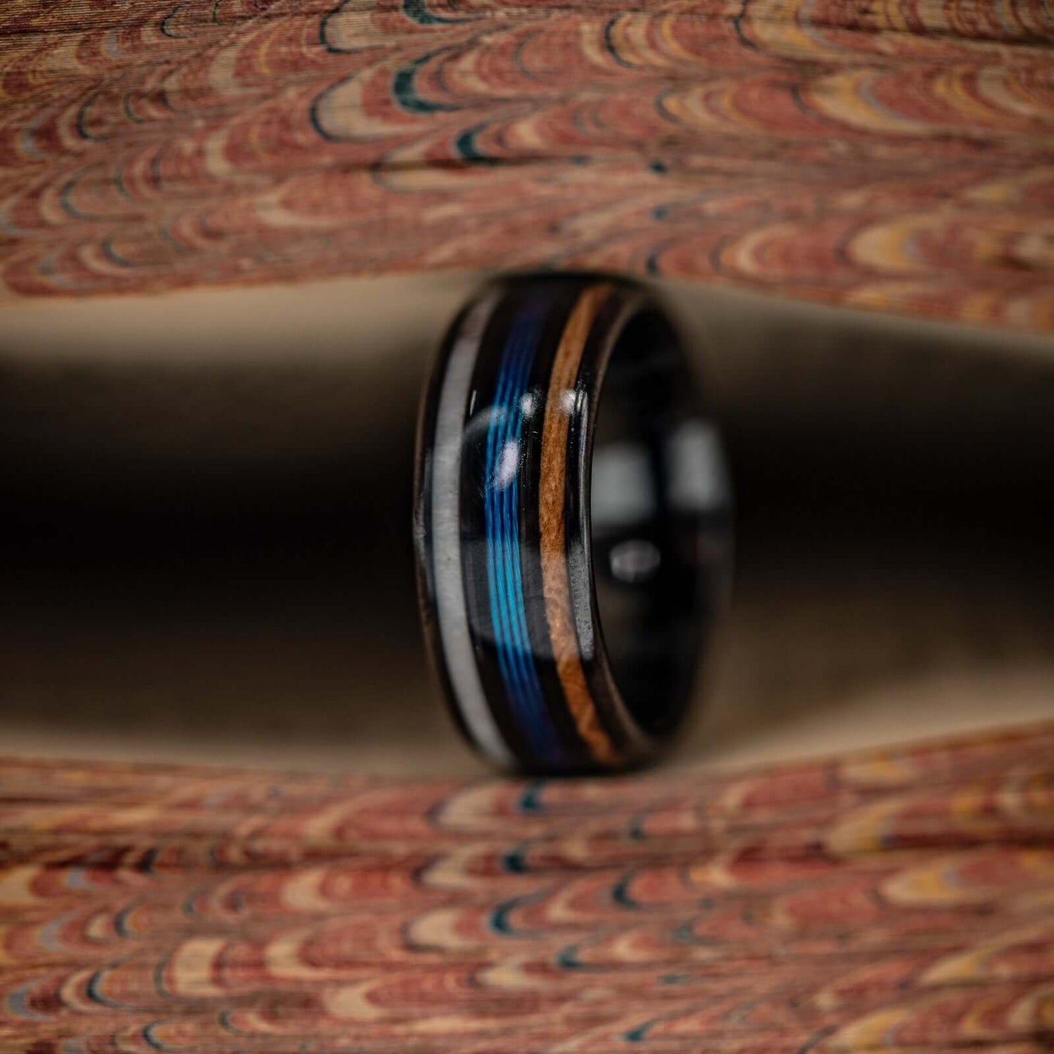 Unique wedding band featuring antler, whiskey barrel wood, and blue fishing line accents.