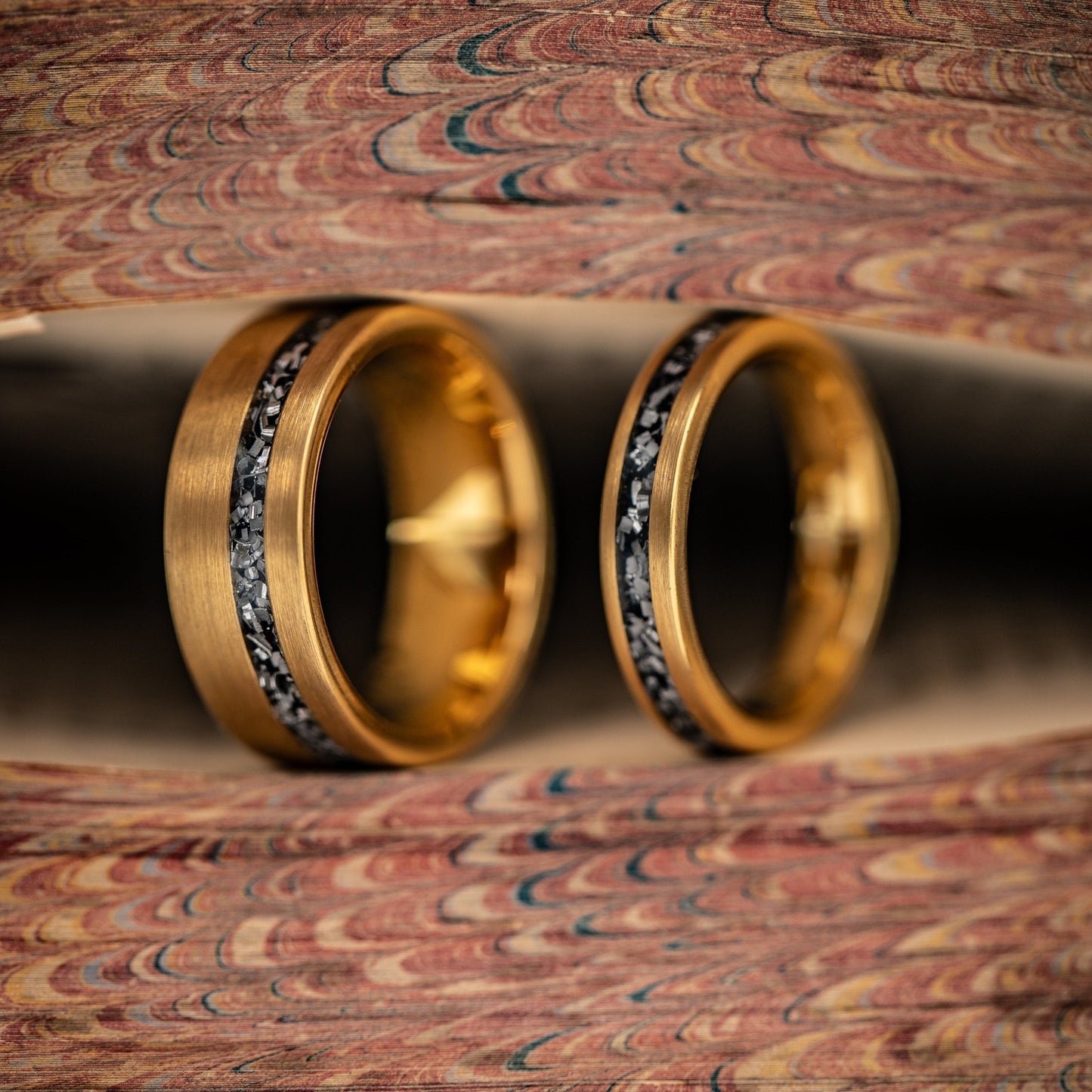 Elegant wedding ring set featuring real meteorite and yellow gold bands for couples.