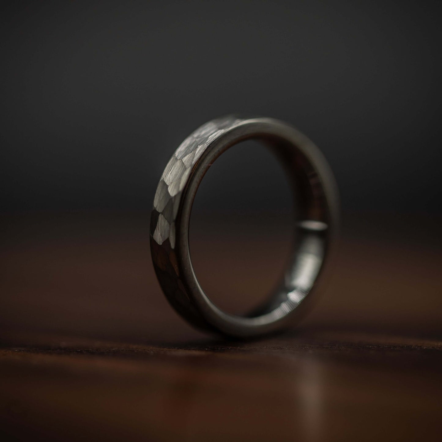 Hammered silver tungsten wedding ring showcasing a bold, rustic design with a polished interior and unique texture.