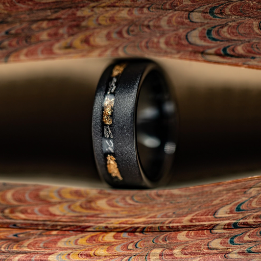 Men's wedding band featuring black and gold accents, with meteorite and gold leaf inlay.