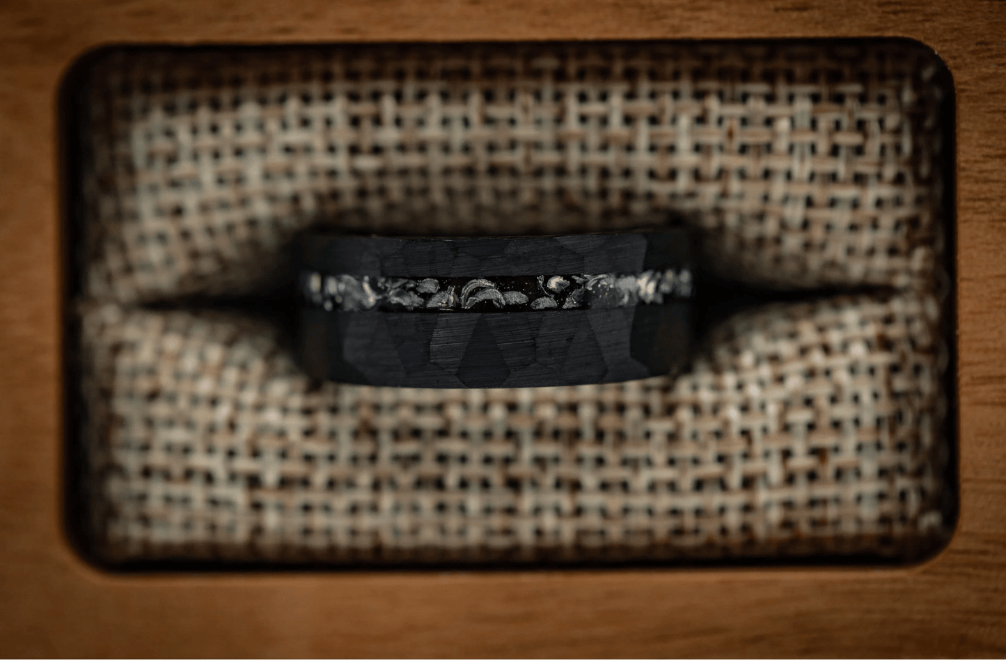 Sleek hammered black ring with meteorite detailing, perfect as a men's wedding band.