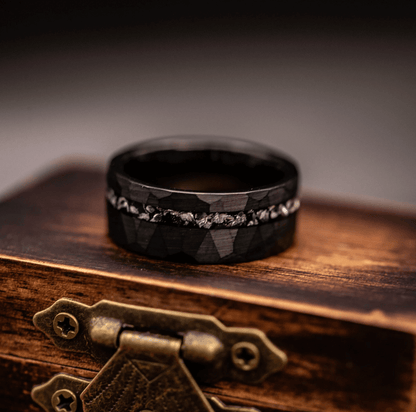 Striking hammered black wedding band with meteorite accents, designed for timeless elegance.