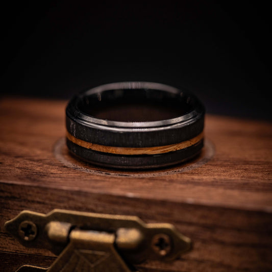 Black brushed tungsten and Hawaiian Koa wood wedding band on a wooden display box.