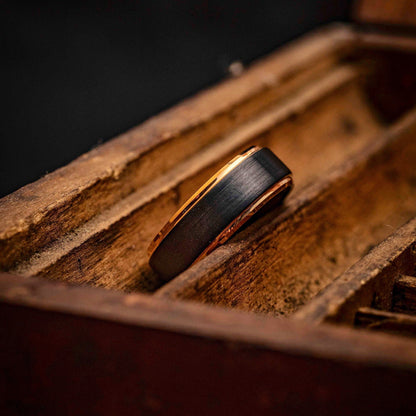 Stylish black wedding or engagement band accented with rose gold plated edges.