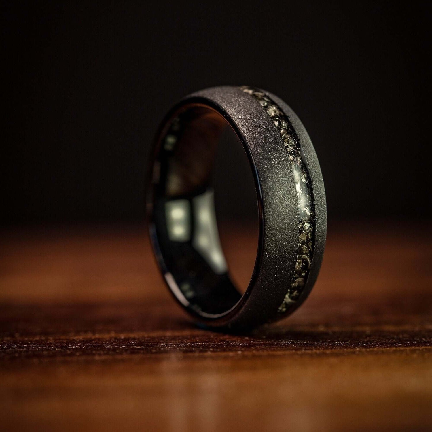 Striking black wedding band featuring a sandblasted finish and genuine meteorite.