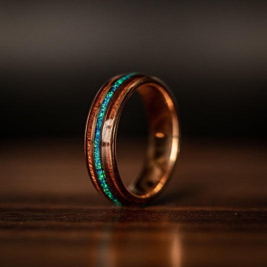 Elegant rose gold wedding band featuring Hawaiian Koa wood and blue opal inlay.